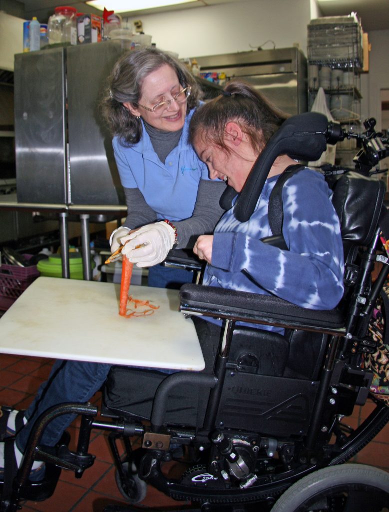 Young woman with cerebral palsy loves community-based cooking class.